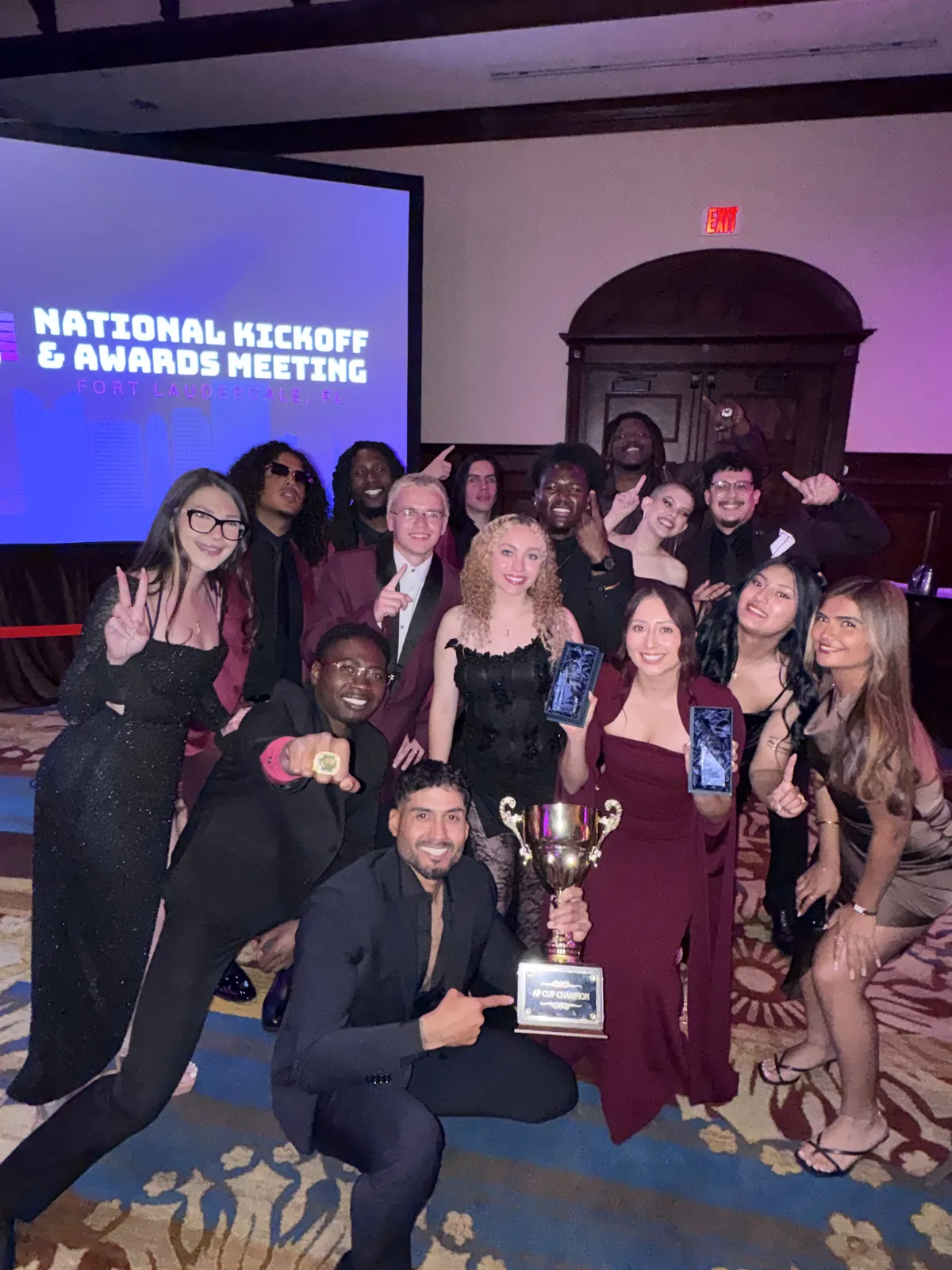 The team celebrating a win with the trophy at the national kickoff and awards meeting