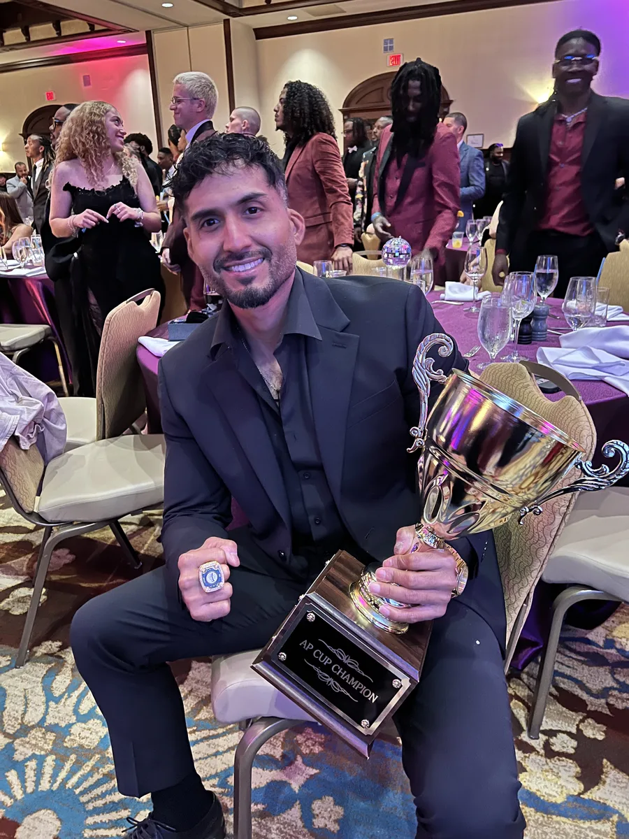 Team member of the month holding the award trophy